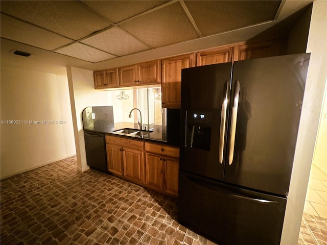 kitchen featuring stainless steel refrigerator with ice dispenser, a drop ceiling, sink, and dishwasher