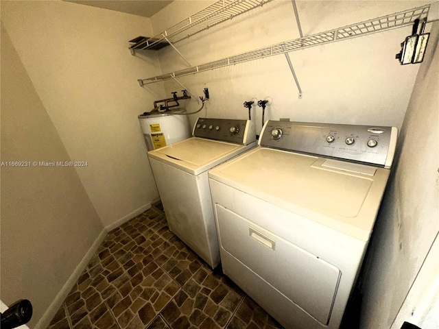 laundry room with water heater and separate washer and dryer