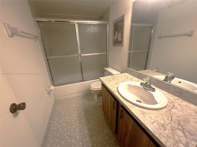 full bathroom featuring shower / bath combination with glass door, vanity, toilet, and tile patterned floors