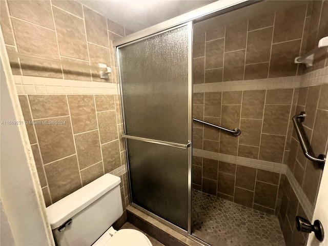 bathroom featuring walk in shower and toilet