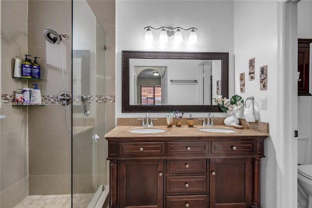 bathroom featuring vanity, a shower with shower door, and toilet