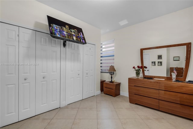 bedroom featuring two closets and light tile patterned floors