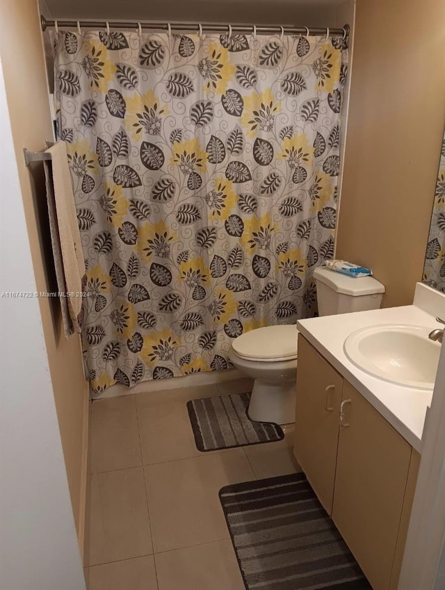 bathroom with curtained shower, vanity, toilet, and tile patterned floors