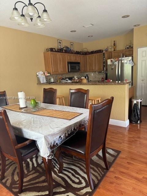 dining area with a notable chandelier and light wood-type flooring