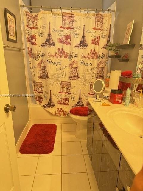 full bathroom with tile patterned flooring, shower / bath combo with shower curtain, vanity, and toilet