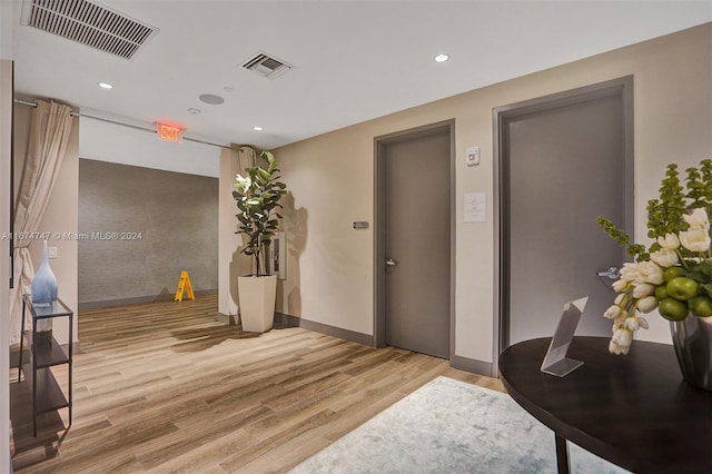 hallway with light hardwood / wood-style floors