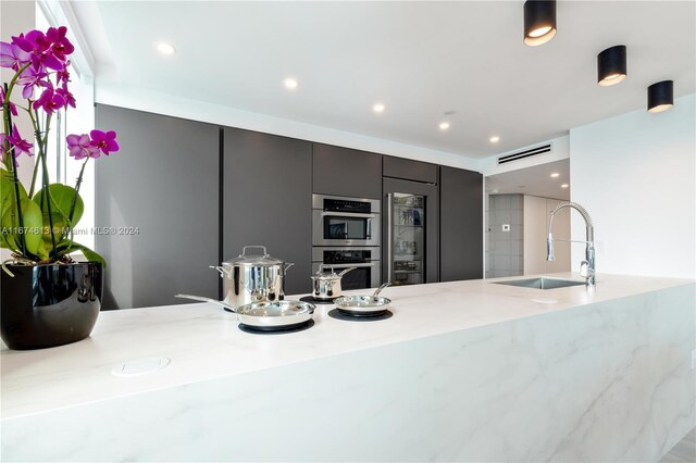 650 W Ave Unit 1101, Miami Beach, FL 33139 - kitchen with double oven, recessed lighting, modern cabinets, light stone countertops, and refrigerator