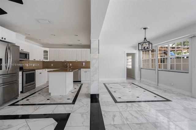 kitchen with white cabinets, stainless steel appliances, backsplash, and a kitchen island