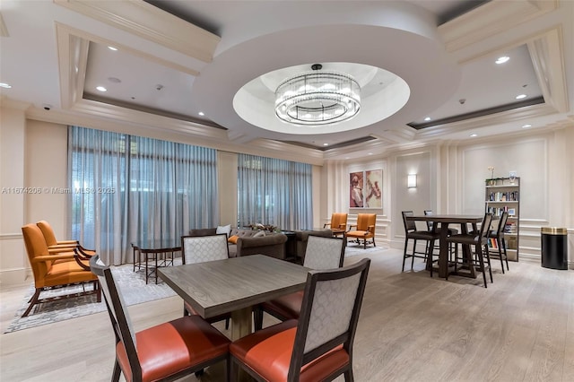 dining space featuring light wood-style flooring, ornamental molding, a notable chandelier, and recessed lighting