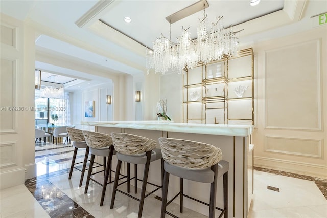 bar featuring a notable chandelier, recessed lighting, a decorative wall, a tray ceiling, and crown molding