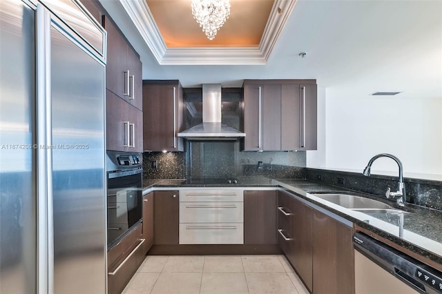 kitchen featuring crown molding, a raised ceiling, a sink, wall chimney range hood, and black appliances