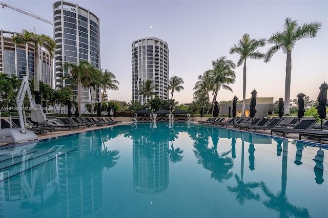 pool at dusk featuring a community pool