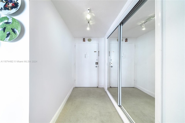 hallway featuring light colored carpet