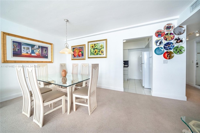 dining area featuring light carpet