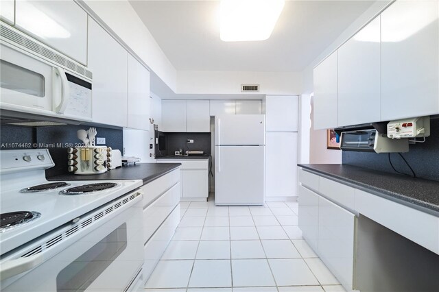 1408 Brickell Bay Dr Unit 1415 & 1416, Miami, FL 33131 - kitchen featuring white appliances, dark countertops, white cabinets, and light tile patterned flooring