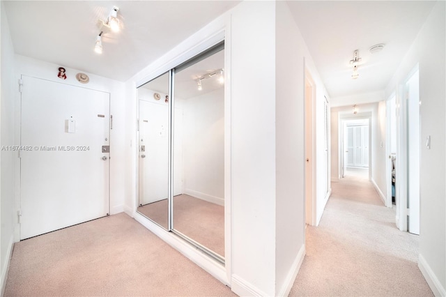 hallway featuring light colored carpet