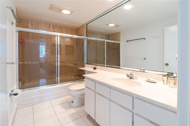 full bathroom featuring toilet, combined bath / shower with glass door, vanity, and tile patterned flooring