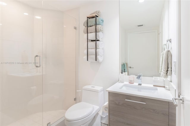 bathroom featuring a shower with shower door, vanity, and toilet