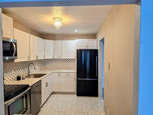 kitchen with backsplash, white cabinets, sink, and black appliances