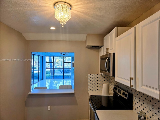 kitchen with light countertops, appliances with stainless steel finishes, backsplash, and white cabinets