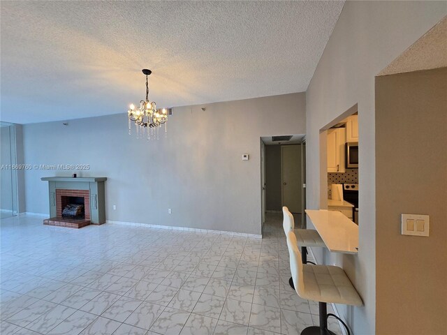 unfurnished living room featuring baseboards, visible vents, a textured ceiling, a fireplace, and floor to ceiling windows