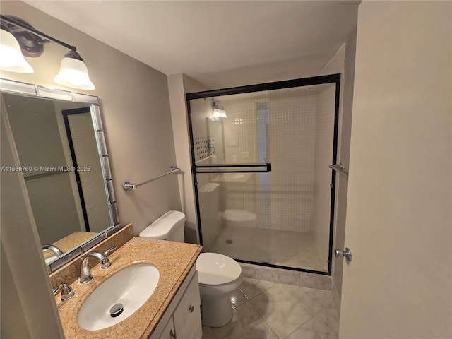 bathroom with a stall shower, vanity, toilet, and tile patterned floors