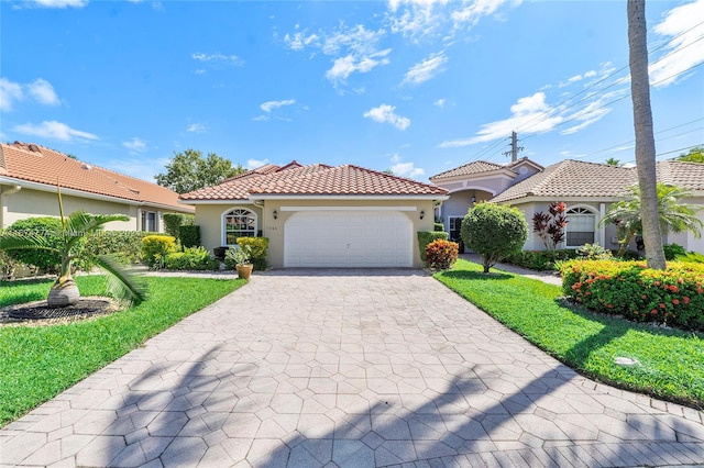 mediterranean / spanish home featuring a front yard and a garage