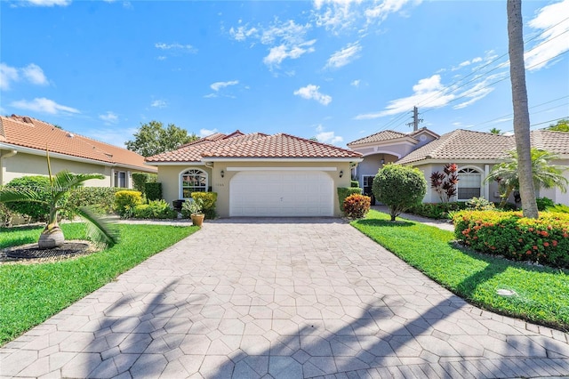 11088 Indian Lake Cir, Boynton Beach, FL 33437 - mediterranean / spanish-style home with stucco siding, a garage, decorative driveway, a tiled roof, and a front lawn