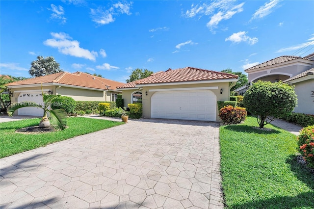 11088 Indian Lake Cir, Boynton Beach, FL 33437 - mediterranean / spanish-style home with stucco siding, an attached garage, a tiled roof, and decorative driveway