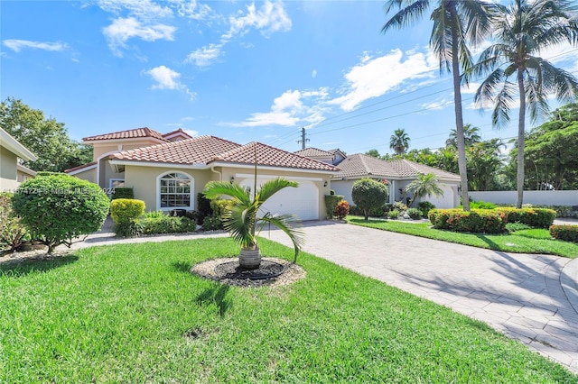 mediterranean / spanish-style home featuring a front lawn and a garage