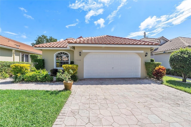 11088 Indian Lake Cir, Boynton Beach, FL 33437 - mediterranean / spanish home with stucco siding, decorative driveway, a tiled roof, and a garage