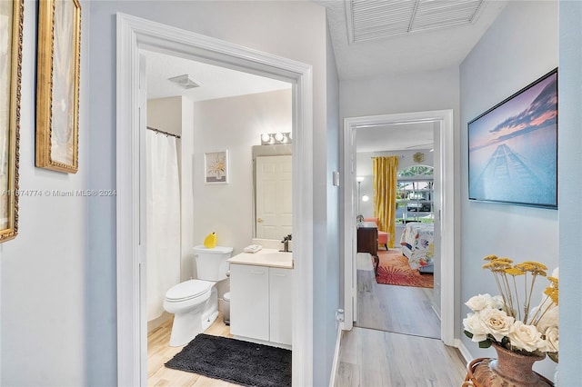 bathroom featuring wood-type flooring, vanity, and toilet