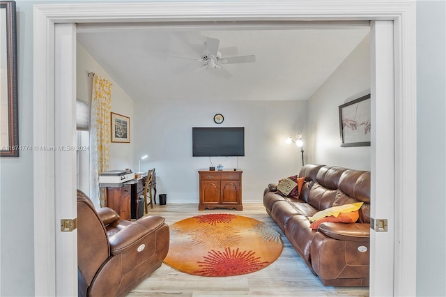 living room featuring ceiling fan, vaulted ceiling, and light hardwood / wood-style floors