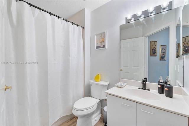 bathroom with toilet, a shower with curtain, hardwood / wood-style flooring, vanity, and a textured ceiling