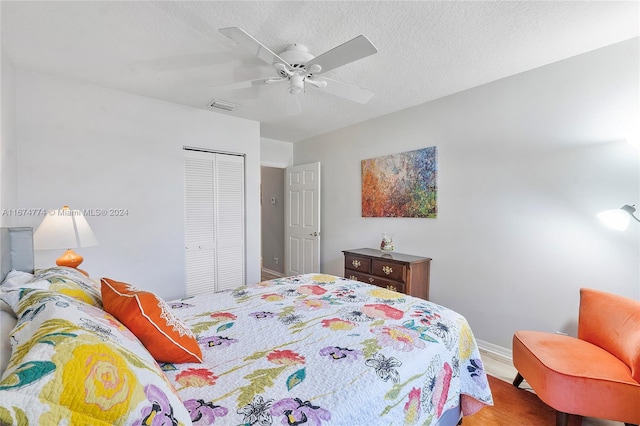 bedroom featuring ceiling fan, hardwood / wood-style flooring, a closet, and a textured ceiling