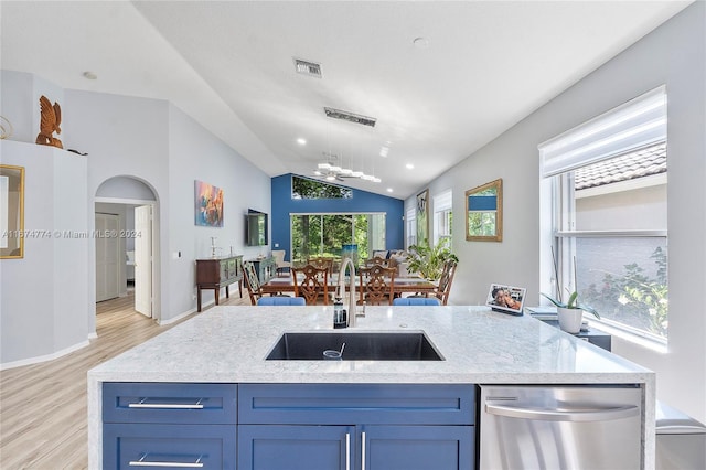 kitchen featuring lofted ceiling, a kitchen island with sink, stainless steel dishwasher, sink, and light hardwood / wood-style flooring