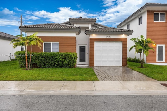 mediterranean / spanish house with a garage and a front yard