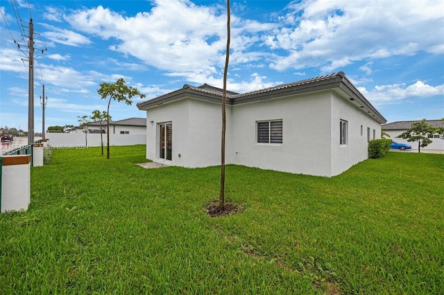 rear view of house featuring a lawn