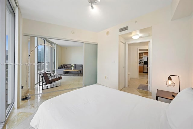 bedroom featuring stainless steel fridge with ice dispenser and a closet