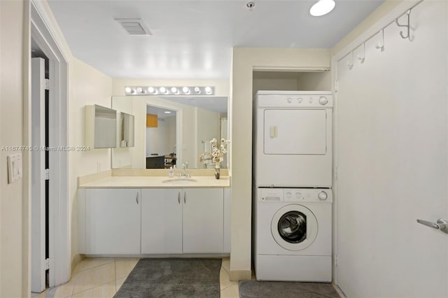 washroom with sink, stacked washer and clothes dryer, and light tile patterned flooring