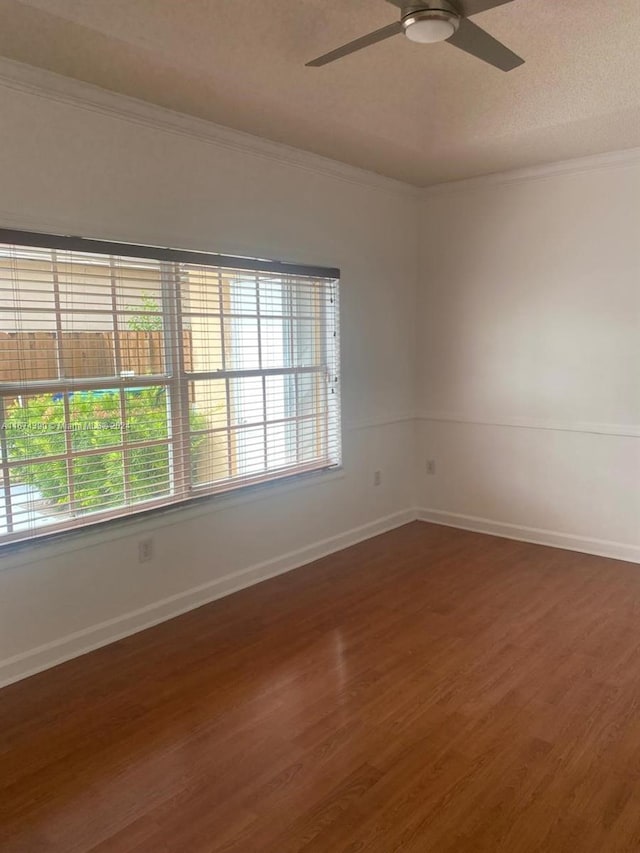 unfurnished room with crown molding, ceiling fan, and dark hardwood / wood-style flooring