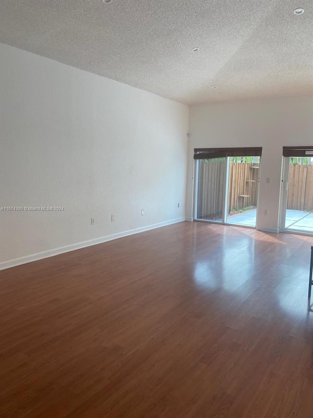 unfurnished room featuring a textured ceiling and dark wood-type flooring