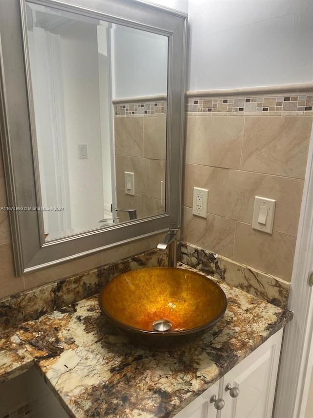 bathroom featuring vanity and tile walls