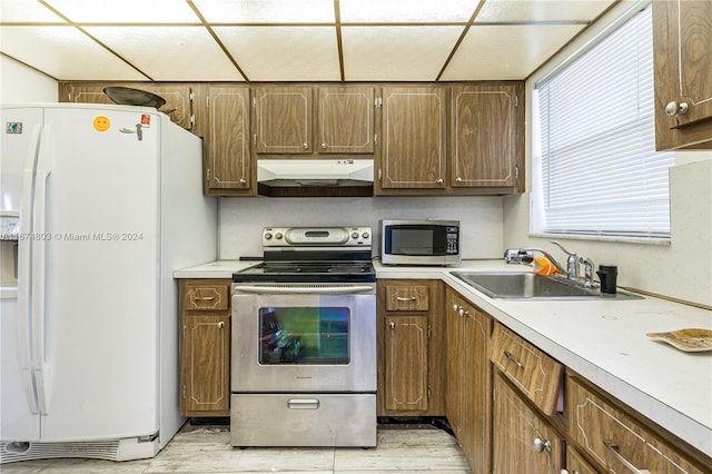 kitchen with sink, stainless steel appliances, and light hardwood / wood-style flooring