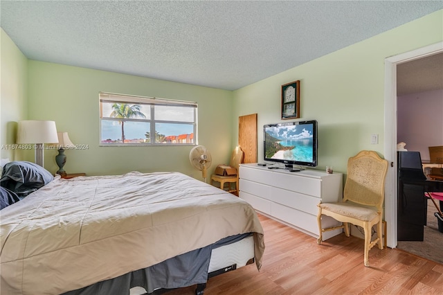 bedroom featuring light wood-type flooring and a textured ceiling