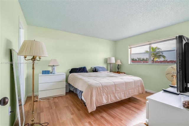 bedroom featuring a textured ceiling and light wood-type flooring