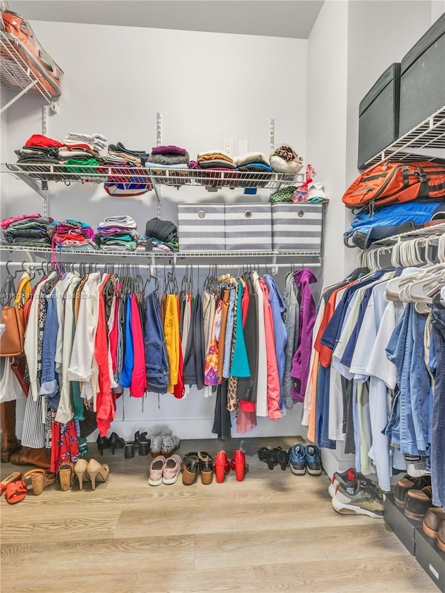 walk in closet with hardwood / wood-style flooring