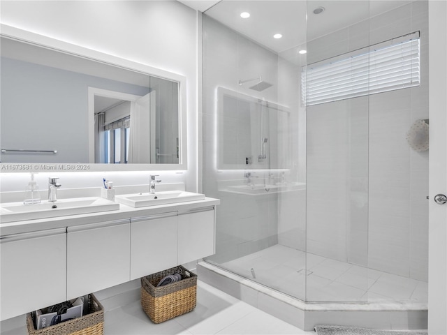 bathroom with a tile shower, vanity, and tile patterned floors