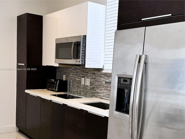 kitchen featuring tasteful backsplash, light tile patterned floors, and appliances with stainless steel finishes