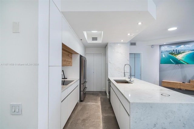 kitchen with appliances with stainless steel finishes, white cabinetry, and sink